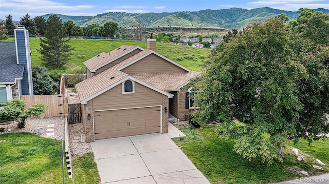10152 Telluride St, Littleton, CO 80125 - view of front facade with brick siding, a mountain view, driveway, a garage, and a gate