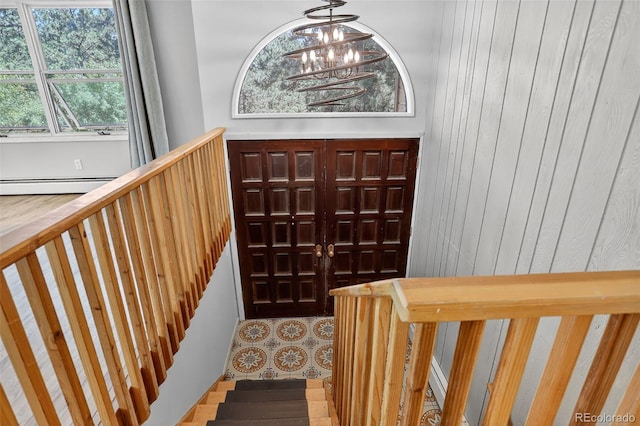 11701 Spruce Canyon Cir, Golden, CO 80403 - entrance foyer featuring a chandelier, a baseboard radiator, wooden walls, and stairway
