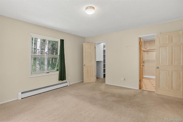11701 Spruce Canyon Cir, Golden, CO 80403 - unfurnished bedroom with a baseboard heating unit, carpet flooring, a spacious closet, a textured ceiling, and connected bathroom