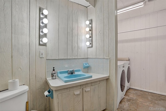 11701 Spruce Canyon Cir, Golden, CO 80403 - half bath featuring washing machine and dryer, vanity, unfinished concrete flooring, and wooden walls