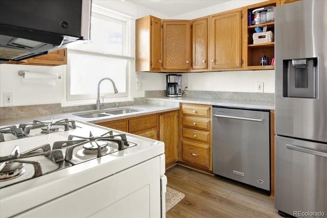 5211 Dover St, Arvada, CO 80002 - kitchen featuring stainless steel appliances, a sink, open shelves, light countertops, and light wood-style floors
