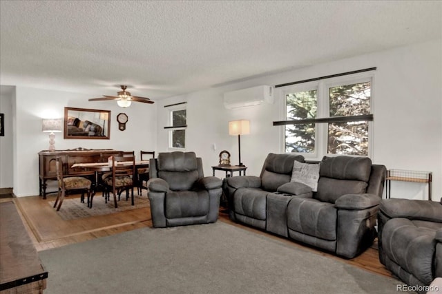 5211 Dover St, Arvada, CO 80002 - living room with a wall mounted AC, wood finished floors, a textured ceiling, and ceiling fan