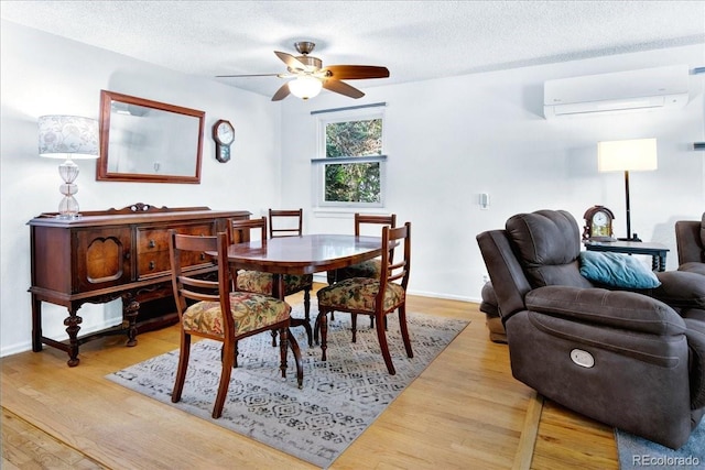 5211 Dover St, Arvada, CO 80002 - dining space with a wall mounted air conditioner, wood finished floors, ceiling fan, a textured ceiling, and baseboards