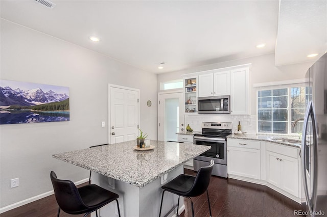 kitchen featuring a breakfast bar, sink, white cabinets, and stainless steel appliances