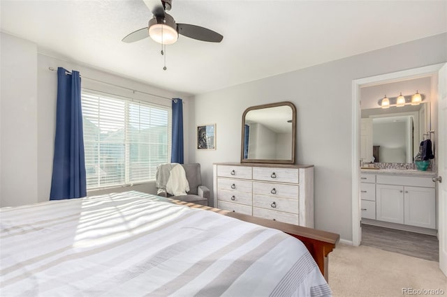 carpeted bedroom featuring ceiling fan and ensuite bath