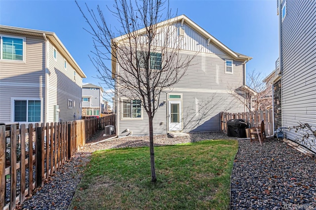 back of house featuring a lawn and central AC unit