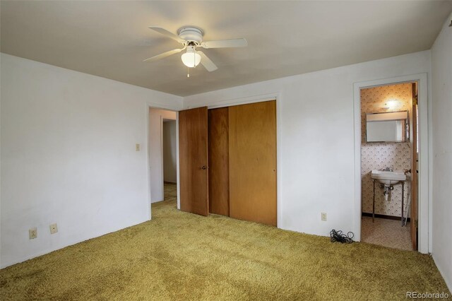 1720 S Balsam St, Lakewood, CO 80232 - unfurnished bedroom featuring a closet, a sink, a ceiling fan, ensuite bath, and carpet flooring
