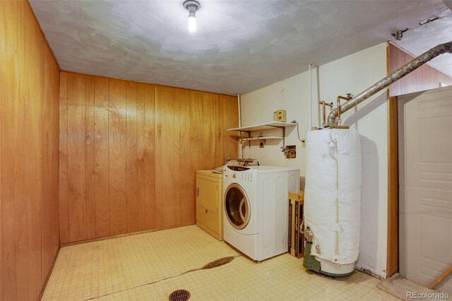 1720 S Balsam St, Lakewood, CO 80232 - clothes washing area featuring water heater, washing machine and dryer, wood walls, laundry area, and light floors