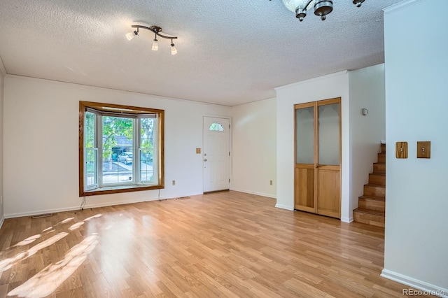 4664 S Zang St, Morrison, CO 80465 - unfurnished living room featuring a textured ceiling, light wood finished floors, and stairway