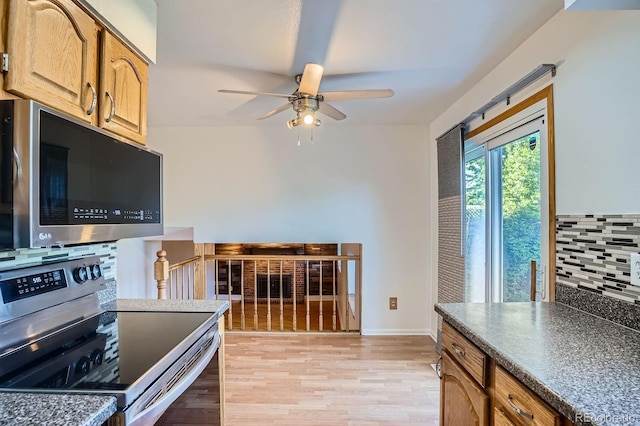 4664 S Zang St, Morrison, CO 80465 - kitchen featuring stainless steel range with electric stovetop, a ceiling fan, light wood-type flooring, backsplash, and dark countertops