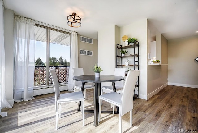 dining area featuring hardwood / wood-style floors and a baseboard heating unit