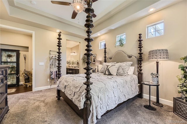 carpeted bedroom with ceiling fan, connected bathroom, and a tray ceiling