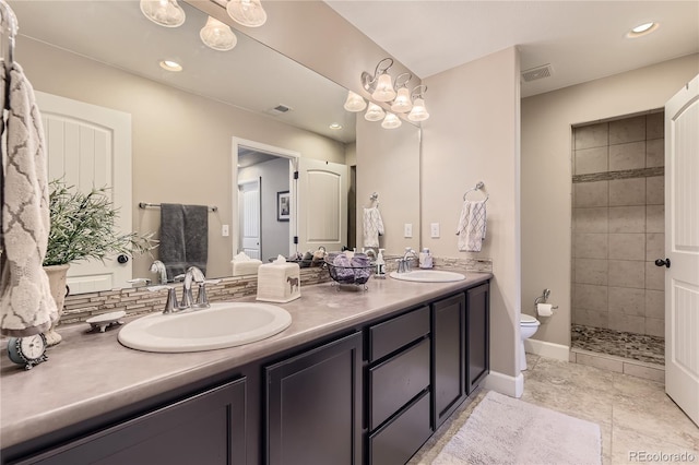 bathroom with toilet, decorative backsplash, a tile shower, and vanity