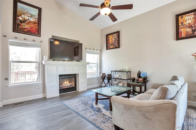 9889 Aftonwood St, Highlands Ranch, CO 80126 - living room featuring ceiling fan, baseboards, a glass covered fireplace, wood finished floors, and high vaulted ceiling