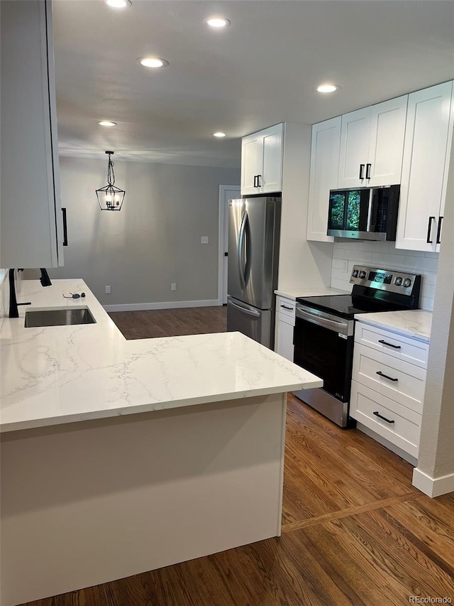 2836 S Fenton St, Denver, CO 80227 - kitchen featuring stainless steel appliances, dark wood-type flooring, light stone countertops, white cabinetry, and recessed lighting