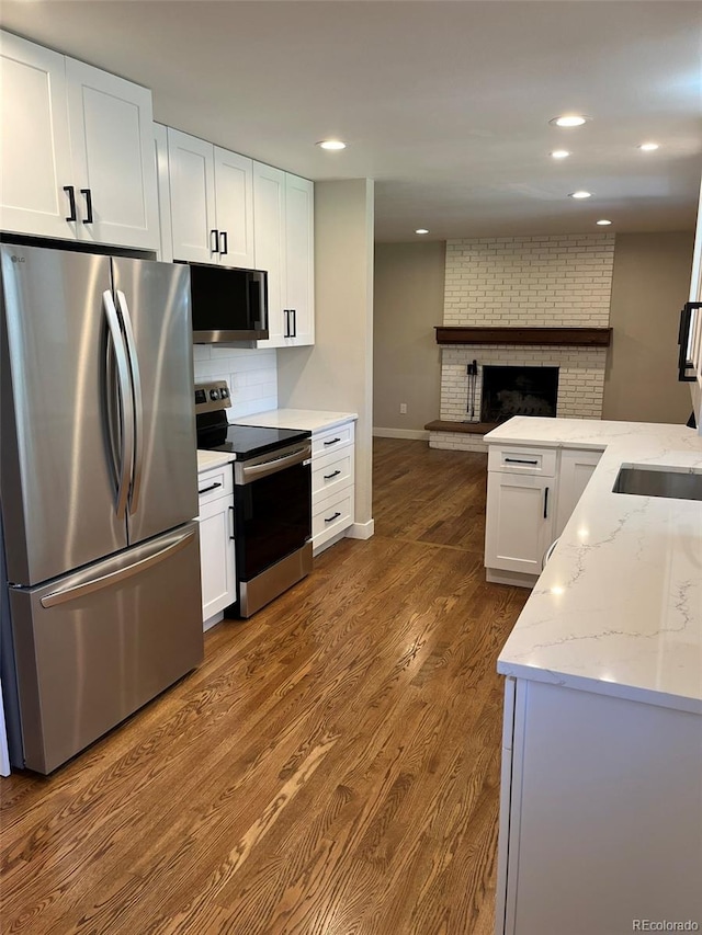 2836 S Fenton St, Denver, CO 80227 - kitchen featuring stainless steel appliances, tasteful backsplash, light stone counters, white cabinetry, and recessed lighting