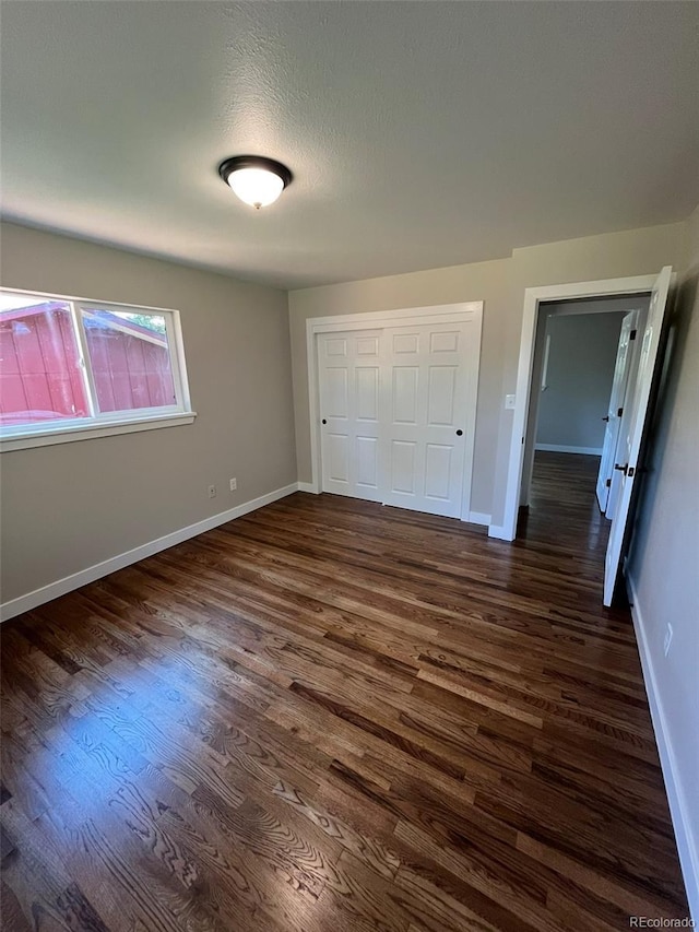 2836 S Fenton St, Denver, CO 80227 - unfurnished bedroom with dark wood-style flooring and a closet