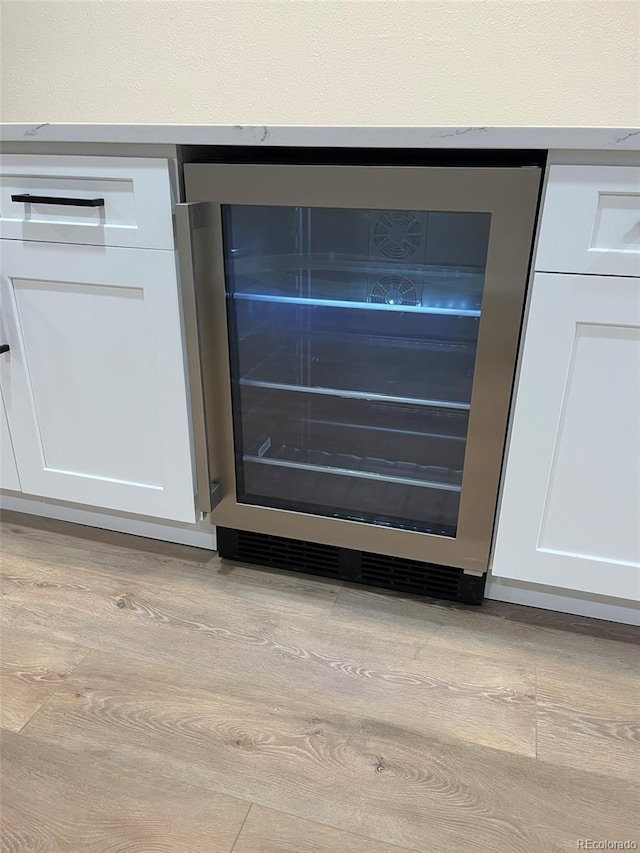 2836 S Fenton St, Denver, CO 80227 - detailed view of wine cooler, white cabinets, and light wood-style floors