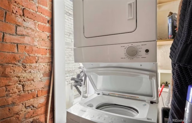 474 N Inca St, Denver, CO 80204 - laundry room featuring stacked washer and clothes dryer and brick wall