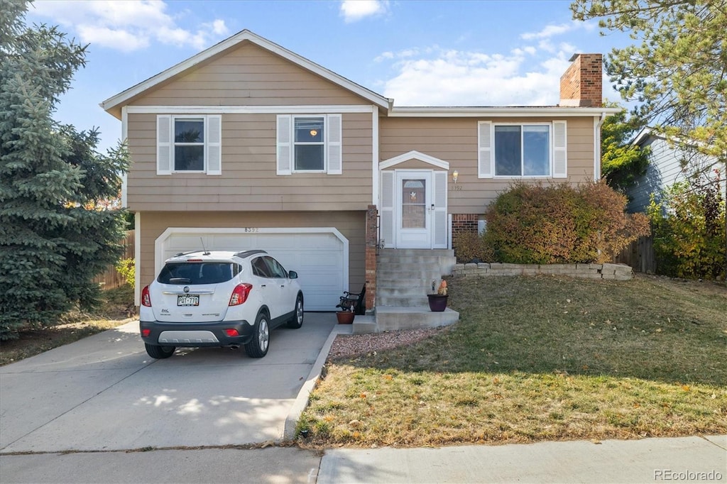 raised ranch with a front yard and a garage