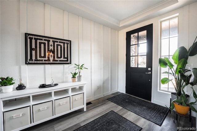 foyer with ornamental molding, wood-type flooring, and a healthy amount of sunlight