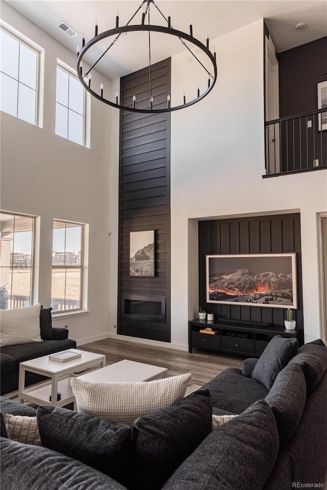 living room with a high ceiling, a large fireplace, and hardwood / wood-style floors