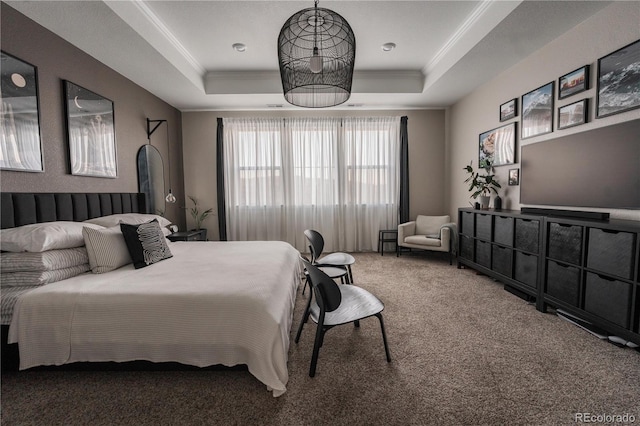 carpeted bedroom with ornamental molding and a tray ceiling