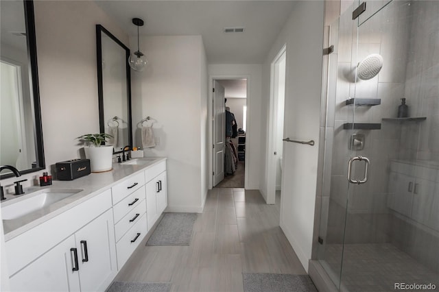 bathroom featuring vanity and a shower with door