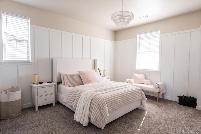 bedroom with multiple windows, carpet floors, and a notable chandelier