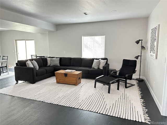 living room with wood-type flooring and a textured ceiling