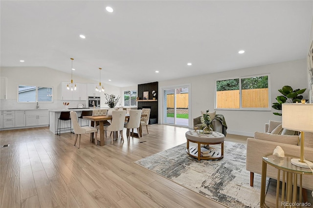 8357 Dudley Ct, Arvada, CO 80005 - living room featuring lofted ceiling, light wood-style floors, and recessed lighting