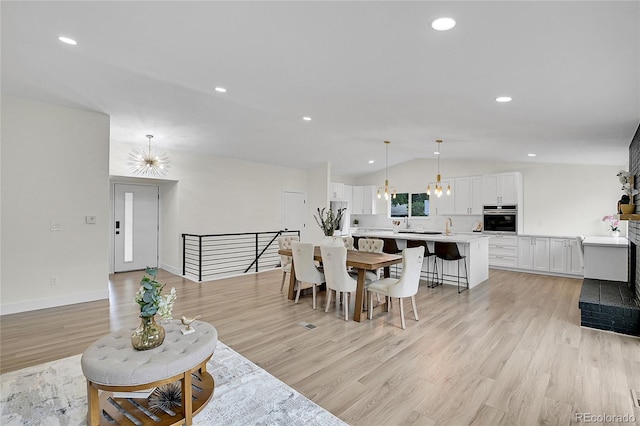 8357 Dudley Ct, Arvada, CO 80005 - living area with vaulted ceiling, light wood-style floors, a chandelier, and recessed lighting