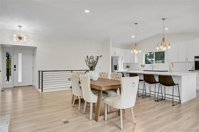 8357 Dudley Ct, Arvada, CO 80005 - dining room featuring a chandelier, vaulted ceiling, light wood-type flooring, and recessed lighting