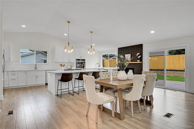 8357 Dudley Ct, Arvada, CO 80005 - dining room with light wood-style flooring, recessed lighting, vaulted ceiling, and a chandelier