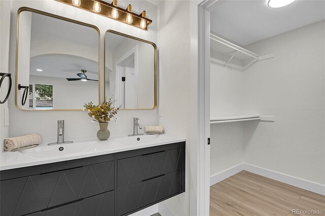 8357 Dudley Ct, Arvada, CO 80005 - bathroom with double vanity, wood finished floors, ceiling fan, and a spacious closet