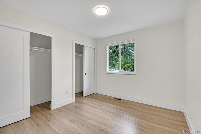 8357 Dudley Ct, Arvada, CO 80005 - unfurnished bedroom featuring two closets and light wood finished floors