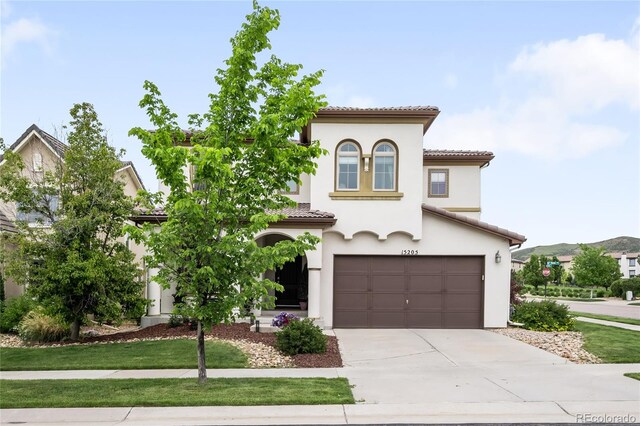 15205 W Baker Ave, Lakewood, CO 80228 - mediterranean / spanish-style house featuring a tiled roof, driveway, a garage, and stucco siding