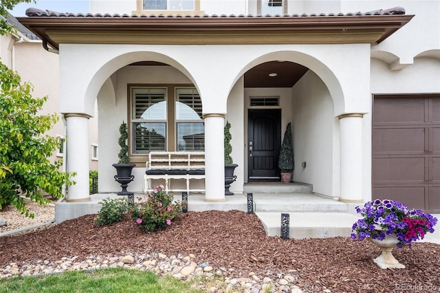 15205 W Baker Ave, Lakewood, CO 80228 - entrance to property featuring covered porch, stucco siding, a tiled roof, and an attached garage