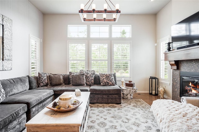 15205 W Baker Ave, Lakewood, CO 80228 - living area featuring wood finished floors, a chandelier, a glass covered fireplace, and baseboards