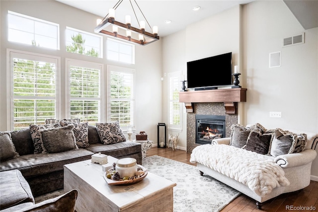 15205 W Baker Ave, Lakewood, CO 80228 - living room with a chandelier, wood finished floors, plenty of natural light, a fireplace, and a towering ceiling