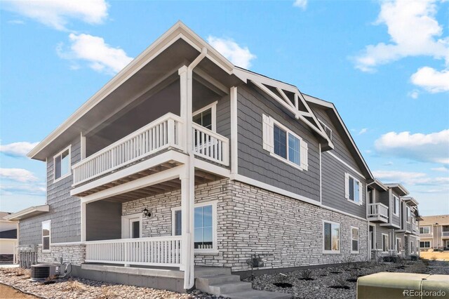 view of home's exterior with central AC and a balcony