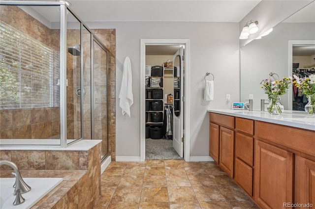 8677 S Buchanan Way, Aurora, CO 80016 - full bathroom featuring a walk in closet, vanity, a shower stall, and a garden tub
