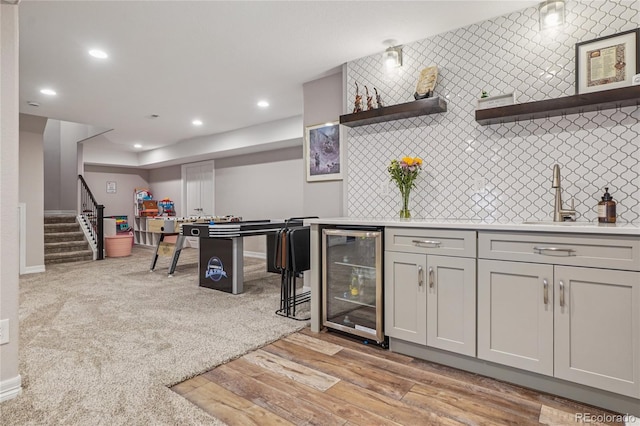 8677 S Buchanan Way, Aurora, CO 80016 - indoor wet bar with wine cooler, recessed lighting, light wood finished floors, stairway, and backsplash