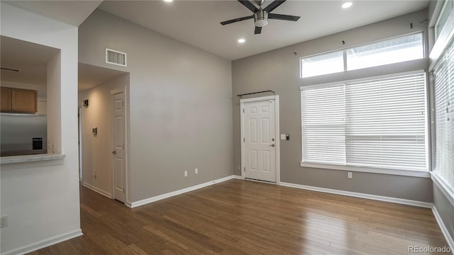 interior space with a towering ceiling, dark hardwood / wood-style floors, and ceiling fan