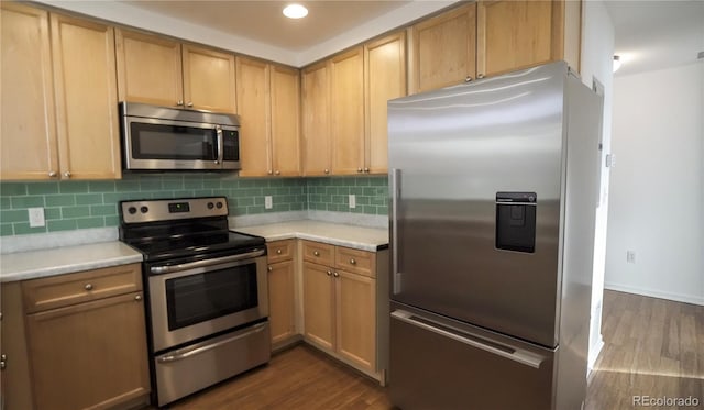 kitchen featuring appliances with stainless steel finishes, dark hardwood / wood-style flooring, light brown cabinetry, and backsplash