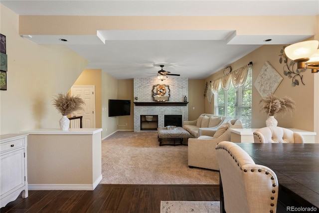 living room with wood-type flooring, a brick fireplace, and ceiling fan