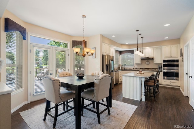 dining area featuring french doors, a healthy amount of sunlight, dark wood-type flooring, and sink