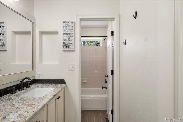 bathroom featuring vanity and tiled shower / bath