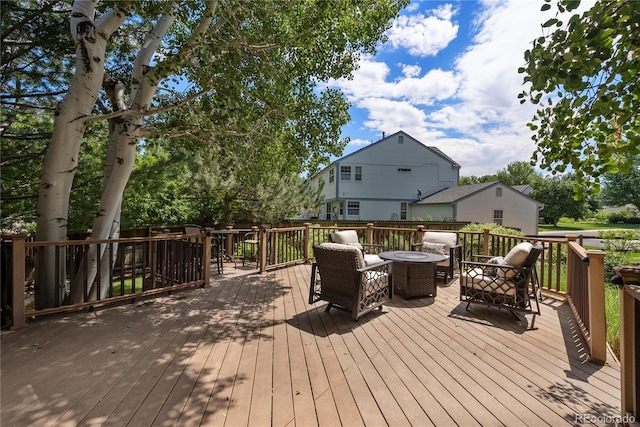 deck featuring an outdoor living space with a fire pit