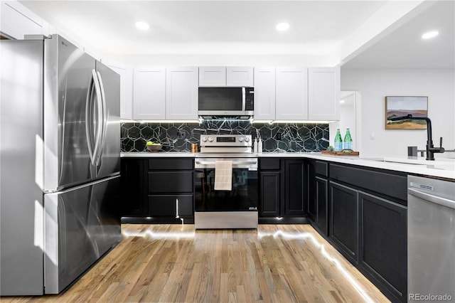 kitchen featuring sink, white cabinets, light wood-type flooring, and appliances with stainless steel finishes